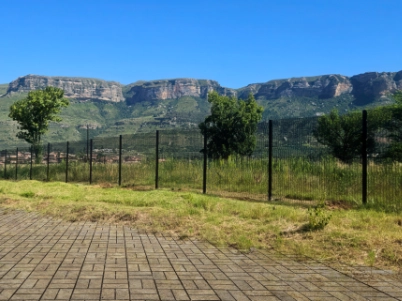 Welded mesh security fencing installed around a commercial property with mountain backdrop, showcasing durable perimeter security solutions.